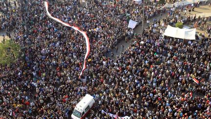 Une ambulance fend la foule sur la place Tahrir au Caire (Egypte), le 22 novembre 2011. (KHALED DESOUKI / AFP)