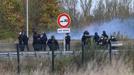 Des policiers utilisent du gaz lacrymogène pour faire reculer des migrants sur l'A16, le 19 novembre 2020, à Calais (Pas-de-Calais). (DENIS CHARLET / AFP)