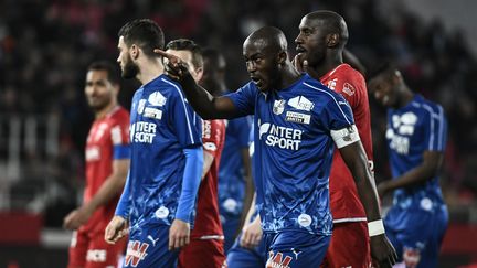 Le joueur d'Amiens Prince Gouano pointe du doigt les tribunes après avoir entendu des cris racistes, le 12 avril 2019 à Dijon (Côte d'Or). (JEFF PACHOUD / AFP)