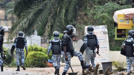 Des policiers démontent une barricade lors d'une manifestation d'étudiants à Abidjan le 13 septembre 2007. (AFP)