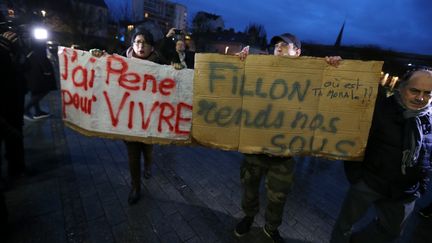 Des manifestants brandissent des pancartes en marge d'un déplacement de François Fillon à Troyes, le 7 février 2017. (FRANCOIS NASCIMBENI / AFP)