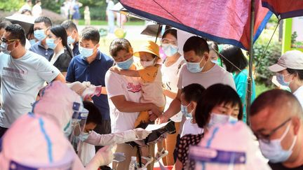 Des résidents de Wuhan (Chine) se font tester contre le Covid-19, le 3 août 2021. (STR / AFP)