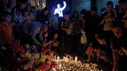 Des personnes viennent déposer fleurs et bougies en mémoire de Charles Aznavour, à Yerevan, en Arménie, le 1er octobre 2018. (KAREN MINASYAN / AFP)