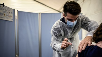 Une personne reçoit une diose de vaccin contre le Covid-19 à Lyon, le 27 novembre 2021. Photo d'illustration. (JEFF PACHOUD / AFP)