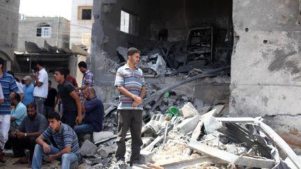 Des Palestiniens dans les d&eacute;combres de la maison du chef de la police du Hamas, bombard&eacute; par l'arm&eacute;e isra&eacute;lienne, le 13 juillet 2014. (MAJDI FATHI / NURPHOTO / AFP)