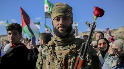 Un soldat entouré de civils, lors d'un rassemblement à Damas (Syrie), le 13 décembre 2024. (BILAL ALHAMMOUD / MIDDLE EAST IMAGES / AFP)