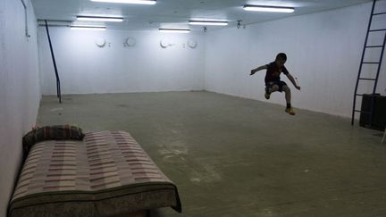 Un jeune Isra&eacute;lien s'amuse dans un bunker &agrave; Beersheba (Isra&euml;l)&nbsp;alors que des roquettes ont &eacute;t&eacute; tir&eacute;es sur la ville par des Palestiniens, le 11 mars 2012. (AMIR COHEN / REUTERS)