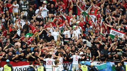 Les joueurs hongrois fêtent leur victoire face à l'Autriche avec leurs supporters. (NICOLAS TUCAT / AFP)