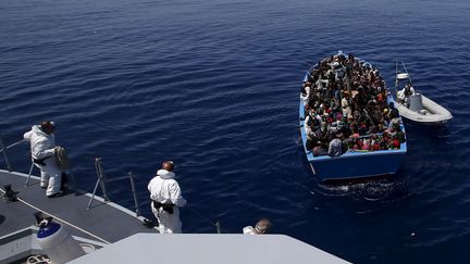 Des garde-c&ocirc;tes italiens viennent au secours d'un bateau transportant 300 migrants venus du continent africain, le 14 mai 2015, au large de la&nbsp;Sicile.&nbsp; (ALESSANDRO BIANCHI / REUTERS)