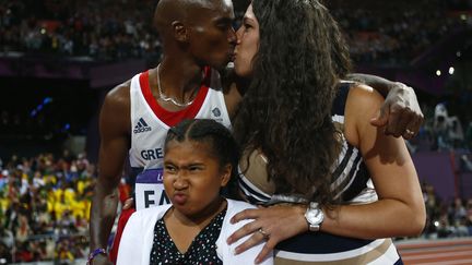 L'anglais Mo Farah prend sa femme dans ses bras apr&egrave;s sa victoire au 10 000m, le 4 ao&ucirc;t. (KAI PFAFFENBACH / REUTERS)