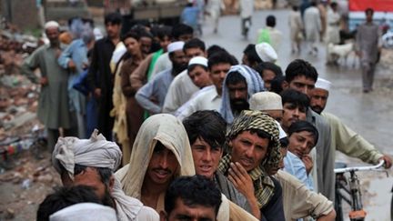 Des Pakistanais attendent de recevoir de l'aide alors que le pays continue à être balayé par la pluie et les inondations (AFP - A. MAJEED)