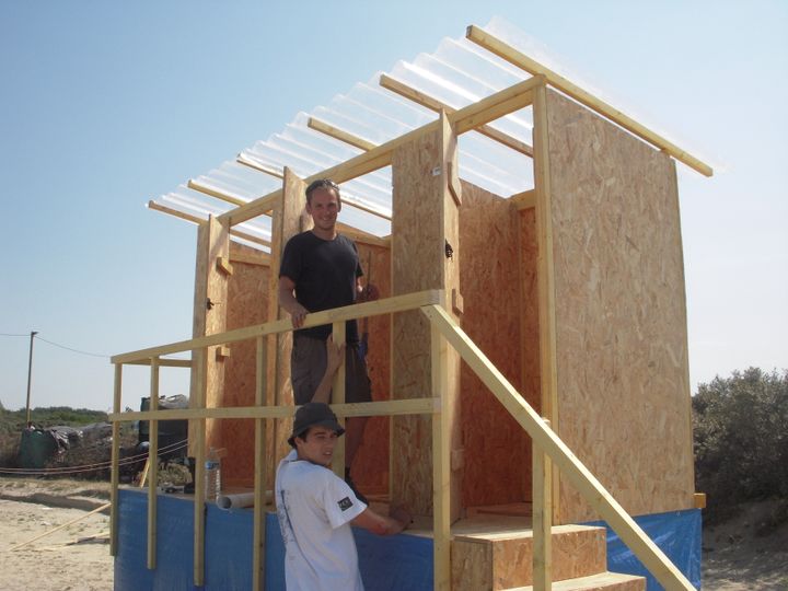 Deux b&eacute;n&eacute;voles de l'ONG Solidarit&eacute;s International construisent des latrines pour les migrants dans la&nbsp;"jungle" de Calais, mercredi 1er juillet 2015. (LOUIS BOY / FRANCETV INFO)