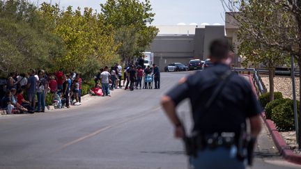 Des personnes évacuées&nbsp;réunies en face du parking d'un hypermarché Walmart où un homme a ouvert le feu, le 3 août 2019, à El Paso (Texas, Etats-Unis). (JOEL ANGEL JUAREZ / AFP)