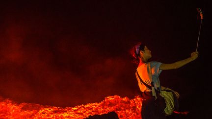 Une femme prend un selfie à proximité d'une coulée de lave. (ERIC LAFFORGUE/ART IN ALL OF US / CORBIS NEWS)