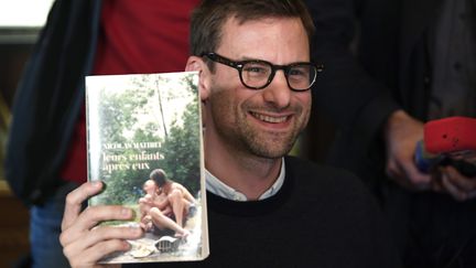 Nicolas Mathieu&nbsp;pose tout sourire après avoir remporté le prix Goncourt. (ERIC FEFERBERG / AFP)