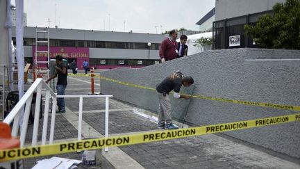 Les hommes travaillent à l'extérieur de l'Institut national électoral à Mexico le 26 juin 2018, avant les élections du 1er juillet. (JOHAN ORDONEZ / AFP)