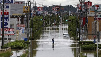 &nbsp; (Un habitant de la ville de Joso, dans la préfecture d'Ibaraki, marche dans sa ville inondée par la rivière Kinugawa. © REUTERS/Issei Kato)