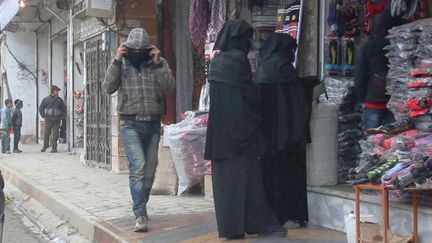 Deux femmes et un homme photographi&eacute;s en mars 2015 dans une rue de Raqqa (Syrie), ville consid&eacute;r&eacute;e comme la capitale de l'organisation Etat islamique. ( NEWSCOM / SIPA )