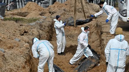 Exhumation de corps à Boutcha, où des gendarmes et docteurs français sont arrivés pour aider à enquêter, le 14 avril 2022. (SERGEI SUPINSKY / AFP)