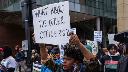 Une manifestante brandit une pancarte "Et les autres policiers ?" à Memphis (Tennessee), pour protester contre l'arrestation de Tyre Nichols mort des suites de ses blessures infligées par des policiers, le 27 janvier 2023. (SETH HERALD / AFP)