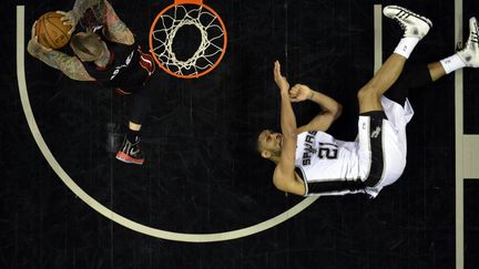 Tim Duncan&nbsp;(D) des Spurs de San Antonio tombe &agrave; terre tandis que le ballon est r&eacute;cup&eacute;r&eacute; par Chris Andersen des Heat de Miami lors du deuxi&egrave;me match de la finale de la NBA &agrave; San Antonio (Texas, Etats-Unis), le 8 juin 2014. (USA TODAY / REUTERS)