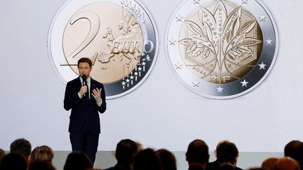 Le secrétaire d'Etat aux Affaires européennes, Clément Beaune, présente la nouvelle pièce de deux euros qui sera mise en circulation en France le 1er janvier 2022, dans le cadre de la présidence française de l'UE, le 9 décembre 2021. (LUDOVIC MARIN / AFP)