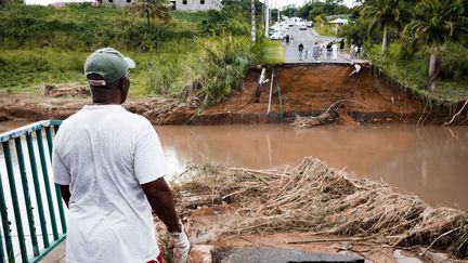 Un habitant devant le pont de Goyave détruit par le passage de la tempête Fiona, le 18 septembre 2022, en Guadeloupe. (CARLA BERNHARDT / AFP)