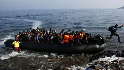 Un migrant afghan sautant du bateau pour rejoindre l’île grecque de Lesbos. 19 octobre 2015.
 (Yannis Behrakis / Reuters)