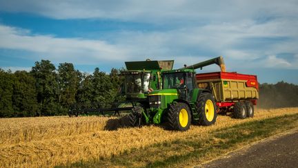 Tracteur et moissoneuse-batteuse en temps de moisson, en juillet 2018, en Haute-Saône. Photo d'illustration. (JEAN-FRANÇOIS FERNANDEZ / FRANCE-BLEU BESANÇON / RADIO FRANCE)