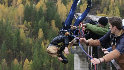 Une femme harnach&eacute;e pour faire du saut &agrave; l'&eacute;lactique est pouss&eacute;e d'un pont haut de 44 m&egrave;tres pr&egrave;s de&nbsp;Krasnoyarsk (Russie), le 29 septembre 2013. (ILYA NAYMUSHIN / REUTERS)