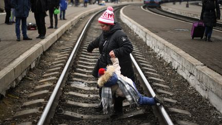 Une mère et son fils dans la gare de Lviv (Ukraine), le 4 mars 2022. (DANIEL LEAL / AFP)