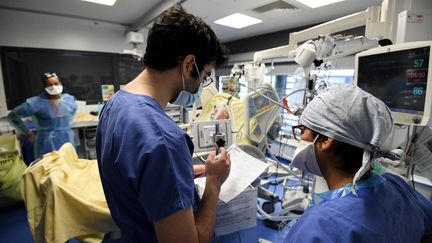 Des soignants s'occupent d'un&nbsp;malade du&nbsp;Covid-19 en réanimation, le 26 janvier 2021, à l'hôpital Tenon, à Paris. (ALAIN JOCARD / AFP)