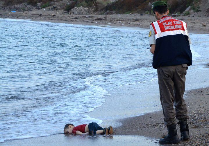 En moins de vingt-quatre heures, la photo est devenue virale, partagée dans le monde entier. Elle montre le corps sans vie d'un petit enfant syrien gisant sur une plage de Bodrum, en Turquie. Face contre terre, le petit Aylan, 3 ans, a été retrouvé par les autorités turques, mercredi 2 septembre, non loin de deux autres corps : ceux de Galip, son frère de 5 ans, et de sa mère, Rehan. Seul Abdullah, son père, a été retrouvé vivant.  (NILUFER DEMIR / DOGAN NEWS AGENCY / AFP)