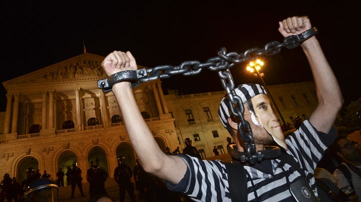 Un manifestant d&eacute;guis&eacute; en prisonnier avec un masque &agrave; l'effigie du Premier ministre portugais Pedro Passos Coelho le 15 septembre 2012 &agrave; Lisbonne. (PATRICIA DE MELO MOREIRA / AFP)