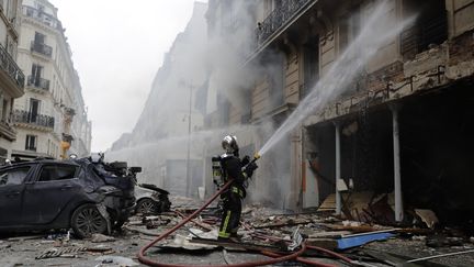 Les pompiers à pied d'oeuvre pour éteindre l'incendie de la boulangerie, dans le 9e arrondissement de Paris.&nbsp; (THOMAS SAMSON / AFP)