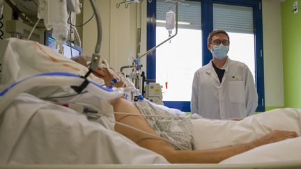 Le Pr&nbsp;Sébastien Gibot, chef du&nbsp;service de réanimation du CHU de Nancy, auprès d'un patient atteint du Covid-19. (JEAN-CHRISTOPHE VERHAEGEN / AFP)