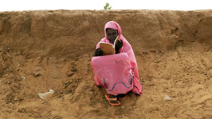 Une habitante du Darfour qui a fui des combats lit un livre, &agrave; El-Fashir (Soudan), le 26 septembre 2013. (MOHAMED NURELDIN ABDALLAH / REUTERS)