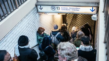 Des passagers du métro parisien devant une grille fermée d'une station de la ligne 13 du métro, le 2 janvier 2020. (MATHIEU MENARD / AFP)