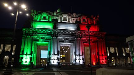 La façade de la gare centrale de Milan illuminée aux couleurs du drapeau italien, le 8 avril 2020. (MAIRO CINQUETTI / NURPHOTO / AFP)