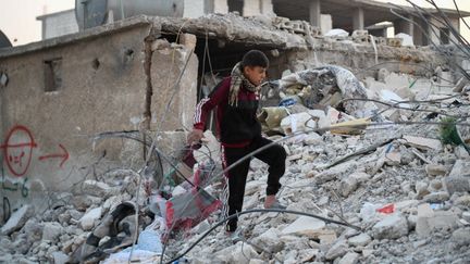 Un habitant devant un bâtiment détruit par le séisme qui a frappé le sud de la Turquie et le nord-ouest de la Syrie, le 13 février 2023 à Jindires (Syrie). (RAMI ALSAYED / NURPHOTO / AFP)