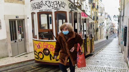 Une femme sort dans le quartier de Bairro Alto, en plein confinement, à Lisbonne (Portugal), le 18 février 2021. (GUSTAVO VALIENTE HERRERO / ANADOLU AGENCY)