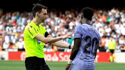 L'arbitre espagnol De Burgos Bengoetxea tente de calmer le Brésilien du Real Madrid Vinicius Junior, lors du match Valence-Real le 21 mai 2023. (JOSE JORDAN / AFP)