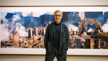 Wim Wenders devant l'une de ses photos du site de Ground Zero, le 10 septembre 2021 à Londres (TOLGA AKMEN / AFP)