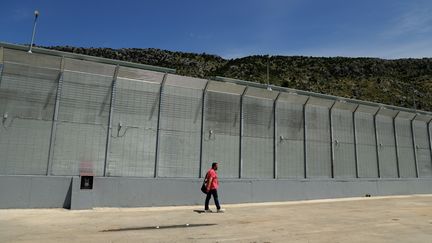 Un homme passe devant un centre pour migrants récemment construit par l'Italie dans le port de Shengjin, à environ 60 km au nord-ouest de Tirana en Albanie, le 5 juin 2024. (ADNAN BECI / AFP)