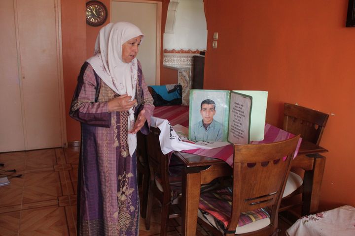 Fatma Zohra Boucherf à côté d'une photo de son fils Riad, le 24 juin 2019, dans son appartement&nbsp;à Alger. (CLEMENT PARROT / FRANCEINFO)