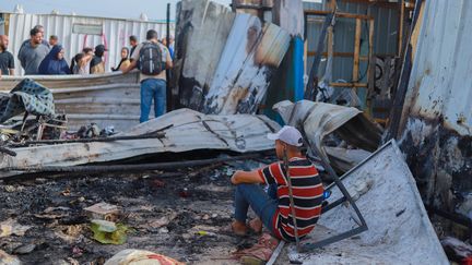 Des Palestiniens sur le site du camp de déplacés touché par une frappe israélienne, le 26 mai 2024. (KHAMES ALREFI / MIDDLE EAST IMAGES)