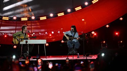 Billie Eilish (D) et son frère Finneas Baird O'Connell(G) sur la scène du Concert pour la planète, le 22 juin 2023 au pied de la Tour Eiffel, à Paris. (ANNA KURTH / AFP)