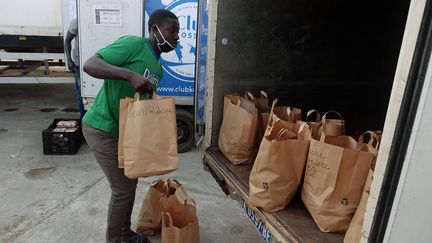 A Dakar, un employé du Club Kossam, entreprise de livraison d'alimentation achetée en ligne, charge un camion avec les commandes des internautes. (CHRISTOPHE VAN DER PERRE / REUTERS)