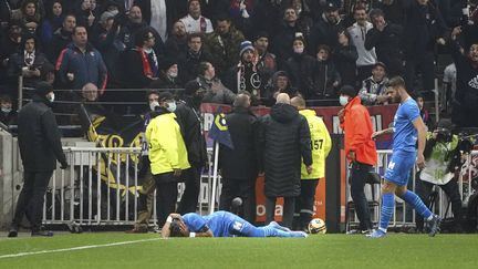 Dimitri Payet à terre après avoir été touché par une bouteille d'eau lancée depuis les tribunes lors du match face entre Marseille et Lyon, dimanche 21 novembre. (LAURENT CIPRIANI/AP/SIPA / SIPA)