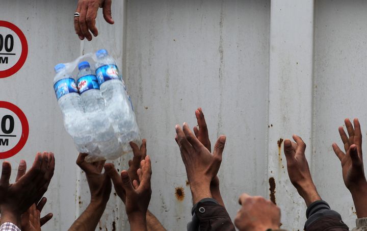 Des déplacés irakiens lors d'une distribution d'eau au camp Hammam al-Alil, au sud de Mossoul, en mars 2017 (AHMAD AL-RUBAYE / AFP)